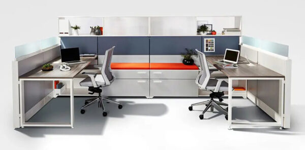 Modern office cubicles with laptops and chairs.