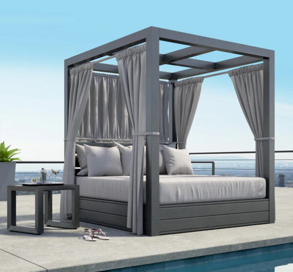 Outdoor canopy bed with curtains by a pool.