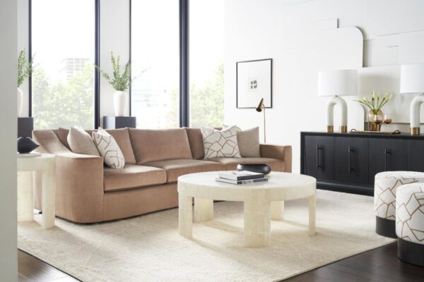 Modern living room with beige sofa and tables.