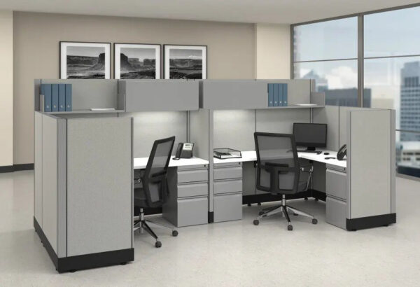 Modern office cubicles with computers and phones.