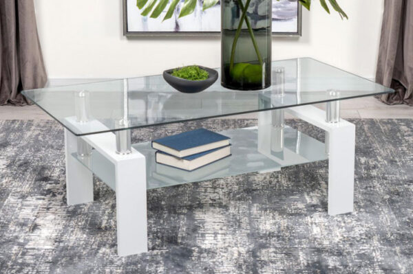 Modern glass coffee table with books and decor.