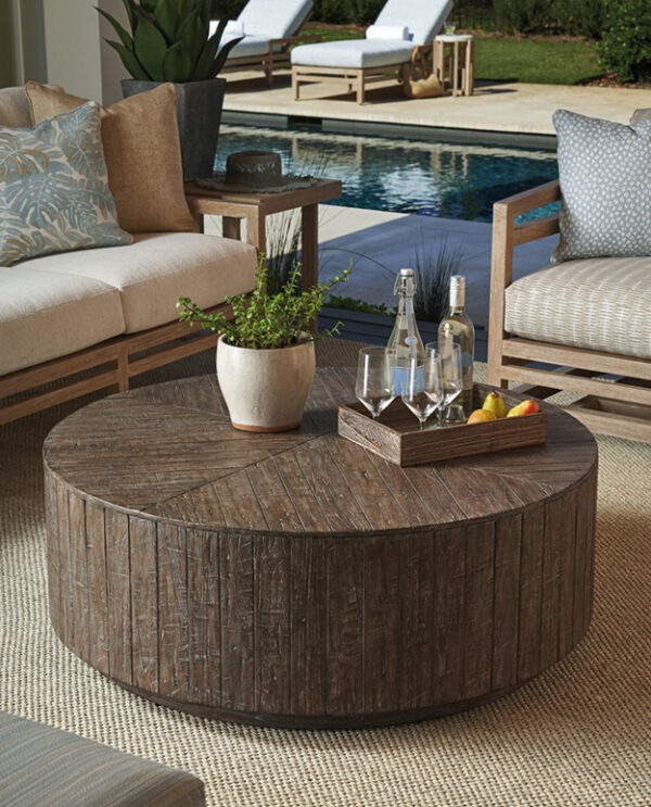 Rustic outdoor patio table with drinks and fruit.