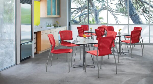 Modern kitchen with red chairs and tables.