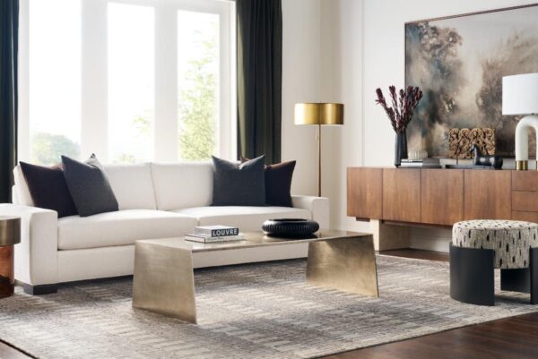 Modern living room with white sofa and gold accents.