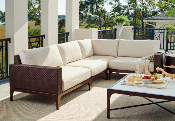 Outdoor patio with beige sectional sofa and table.