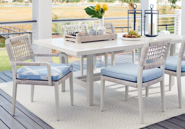 Outdoor dining table with blue cushioned chairs.