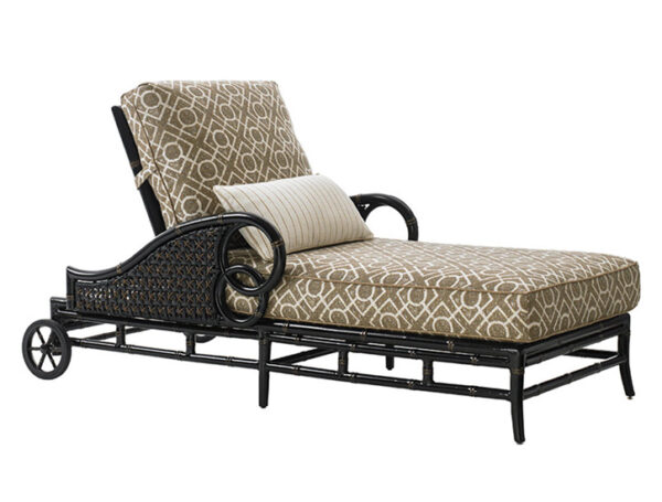 Elegant wicker chaise lounge with patterned cushion.