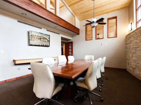 Spacious conference room with wood accents and chairs.