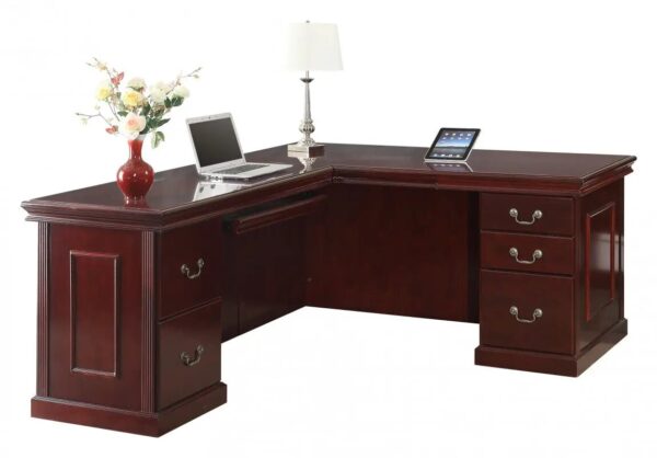 L-shaped wooden desk with laptop and flowers