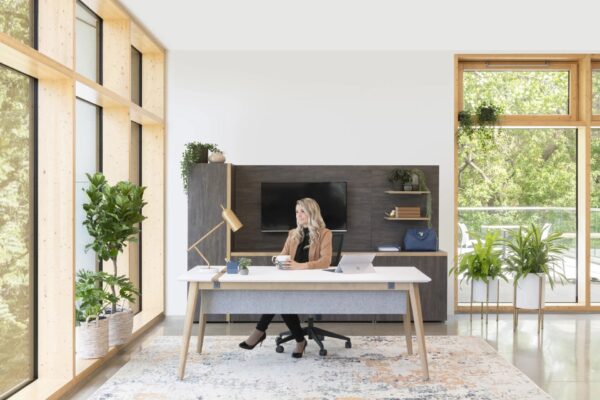 Woman working in bright, modern office with plants.